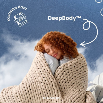 Frau kuschelt sich in eine cremefarbene Grobstrick-Gewichtsdecke